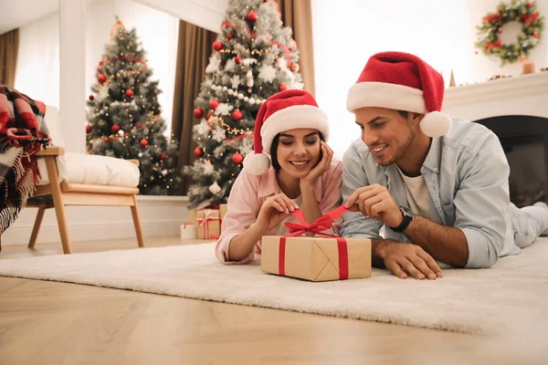 Счастливая Пара Шляпах Санты Рождественским Подарком Дома — стоковое фото