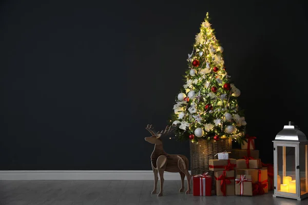Gyönyörű Karácsonyfa Ünnepi Dekoráció Ajándékdobozok Közelében Fekete Fal Beltérben Hely — Stock Fotó