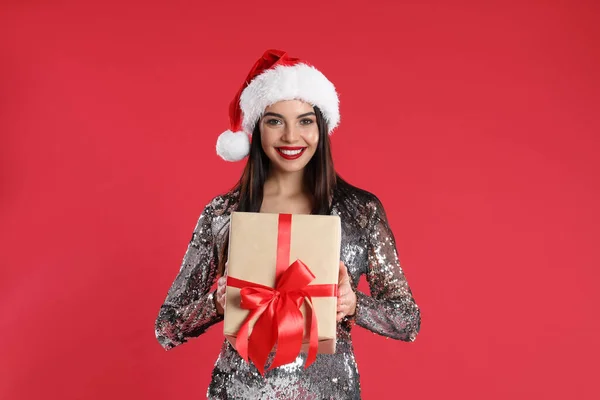 Gümüş Elbiseli Bir Kadın Kırmızı Arka Planda Noel Baba Şapkalı — Stok fotoğraf