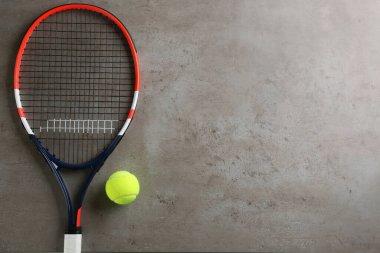 Tenis raketi ve top gri masada, düz yatıyordu. Metin için boşluk