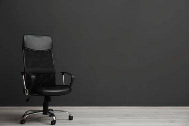 İçerideki siyah duvarın yanında rahat bir ofis sandalyesi. Metin için boşluk