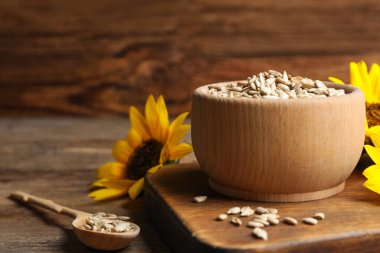 Çiğ ayçekirdeği ve çiçekler ahşap masada. Metin için boşluk