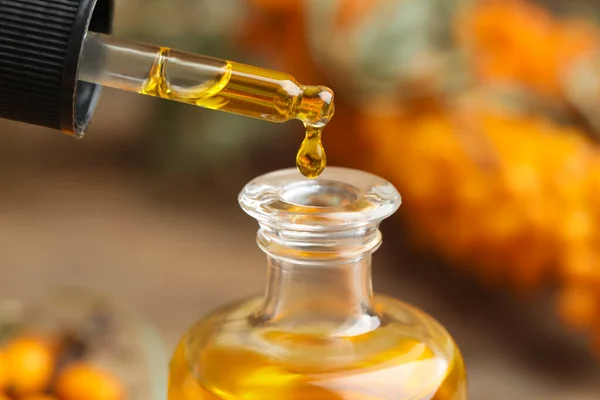 Natural Sea Buckthorn Oil Dripping Pipette Bottle Blurred Background Closeup — Stock Photo, Image