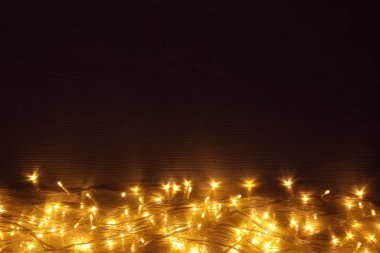 Ahşap masada parlayan güzel Noel ışıkları, üst manzara. Metin için boşluk