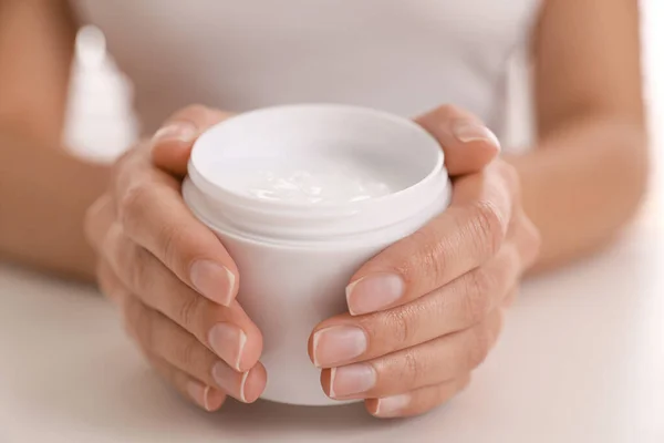 Mujer Con Frasco Crema Hidratante Mesa Blanca Primer Plano — Foto de Stock