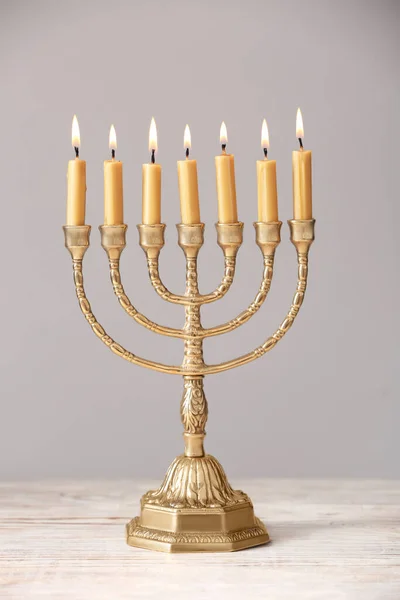 Gyllene Menorah Med Brinnande Ljus Bordet Mot Ljusgrå Bakgrund — Stockfoto