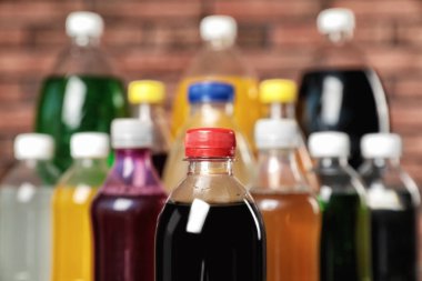 Bottles of soft drinks near brick wall, closeup