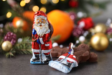 Çikolatalı Noel Baba şekerlemeleri gri masada.