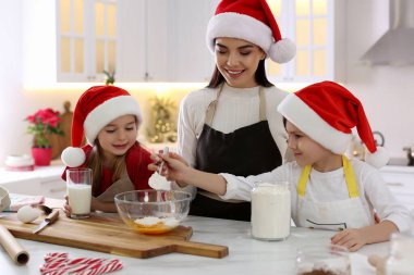 Anne ve tatlı çocukları mutfakta Noel kurabiyesi yapıyorlar.