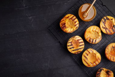 Lezzetli ızgara şeftali ve siyah masada bal, üst manzara. Metin için boşluk