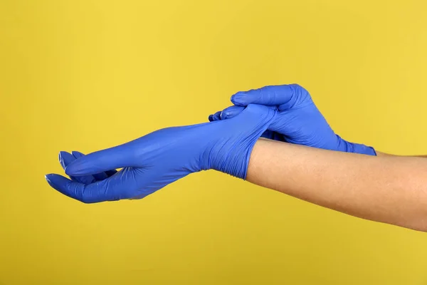 Frau Zieht Blaue Latex Handschuhe Vor Gelbem Hintergrund Nahaufnahme Der — Stockfoto