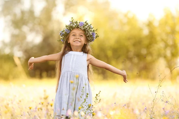 かわいい女の子の花の花輪を屋外で身に着けている 自然の中で過ごす子供たち — ストック写真