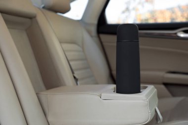 Arabanın içinde siyah termos var.