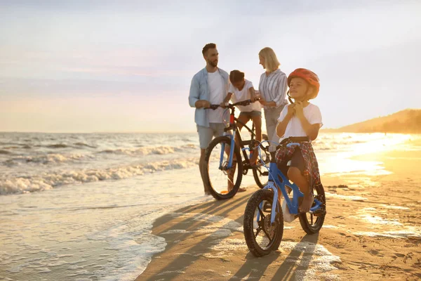 Χαρούμενη Οικογένεια Ποδήλατα Στην Αμμώδη Παραλία Κοντά Στη Θάλασσα — Φωτογραφία Αρχείου