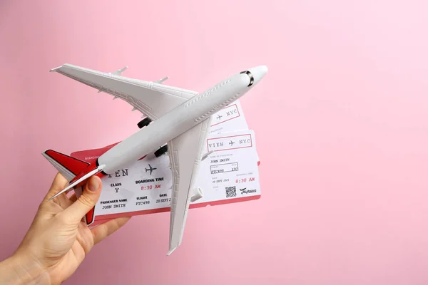Γυναίκα Κρατώντας Αεροπλάνο Παιχνίδι Και Εισιτήρια Ροζ Φόντο Closeup — Φωτογραφία Αρχείου