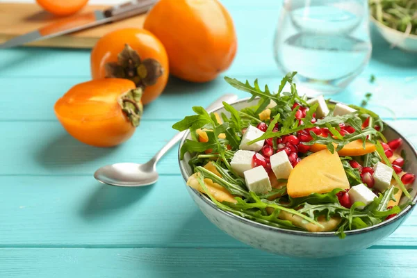 薄緑色の木のテーブルの上にザクロとアルグラとおいしい柿のサラダ — ストック写真