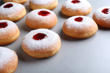 Hanukkah doughnuts with jelly and sugar powder on grey background, closeup