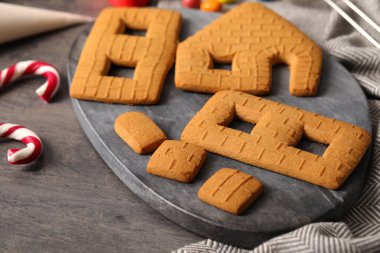 Parts of gingerbread house on grey table, closeup
