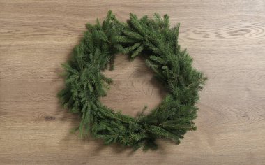 Christmas wreath made of fir branches on wooden background