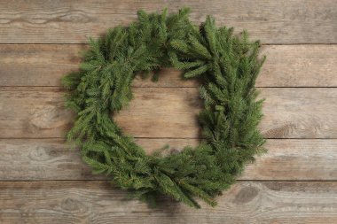 Christmas wreath made of fir branches on wooden background