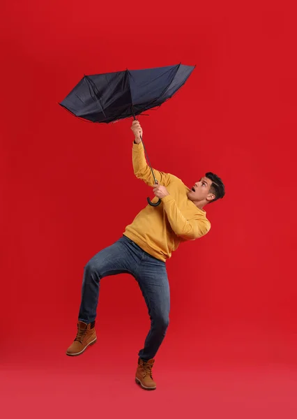 Hombre Emocional Con Paraguas Atrapado Ráfaga Viento Sobre Fondo Rojo — Foto de Stock