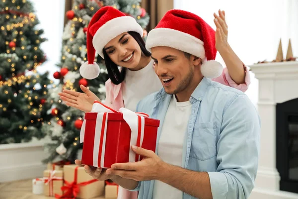 Onnellinen Pari Santa Hatut Joululahja Kotona — kuvapankkivalokuva