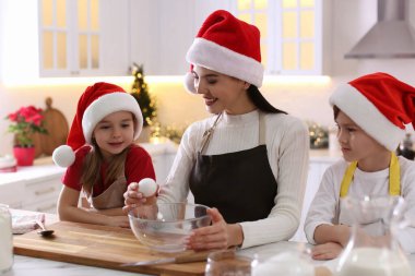 Anne ve tatlı çocukları mutfakta Noel kurabiyesi yapıyorlar.