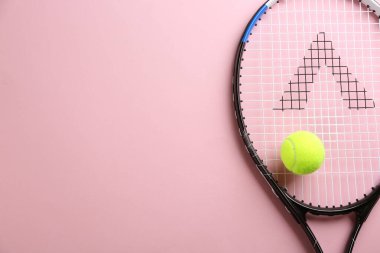 Tenis raketi ve top pembe arka planda, üst manzara. Metin için boşluk