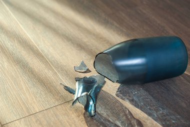 Ahşap zeminde kırık mavi cam vazo. Metin için boşluk