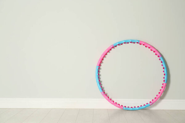 Hula hoop near light wall in gym. Space for text