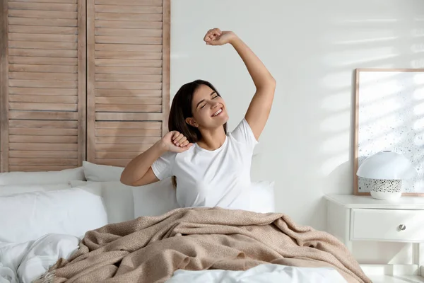 Woman Covered Warm Beige Plaid Stretching Bed Indoors — Stock Photo, Image