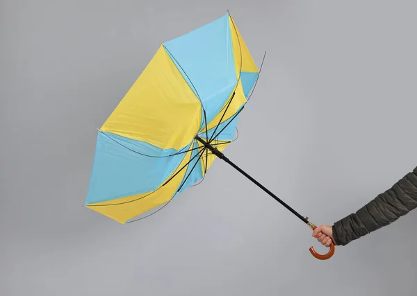 Mann Mit Regenschirm Gefangen Windböen Auf Grauem Hintergrund Nahaufnahme — Stockfoto