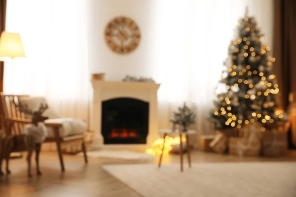 Beautiful living room interior with decorated Christmas tree and modern fireplace, blurred view