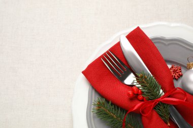 Güzel bulaşık takımları ve beyaz arka planda Noel dekoru olan şenlik masası, üst manzara. Metin için boşluk