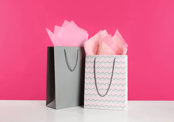 白色桌子上有粉红背景的礼品袋 — 图库照片