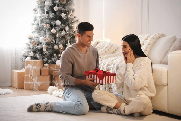 Přítel Dává Vánoční Dárek Box Jeho Přítelkyni Obývacím Pokoji — Stock fotografie