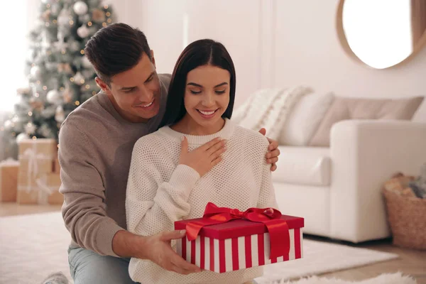 Boyfriend Giving Christmas Gift Box His Girlfriend Living Room — Stock Photo, Image