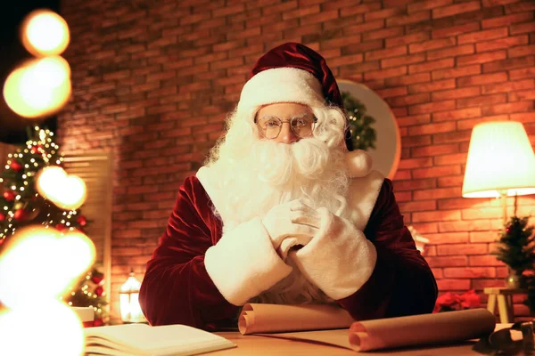 Weihnachtsmann Mit Wunschzettel Bei Tisch Drinnen — Stockfoto