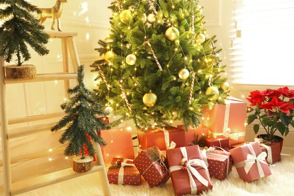 屋内でクリスマスツリーの下に多くの異なる贈り物 — ストック写真