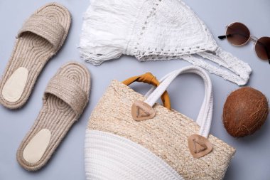 Gri arka planda saman çanta ve yaz aksesuarları, düz yatış