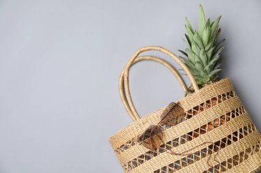 Gri arkaplanda saman torbası ve güneş gözlüğü, metin için yeri olan düz bir yer. Yaz aksesuarları