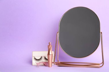 Mor arka planda manyetik kirpikleri ve aksesuarları var. Metin için boşluk