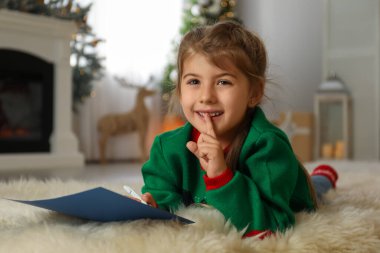 Evde Noel Baba 'ya mektup yazan sevimli bir çocuk. Noel geleneği
