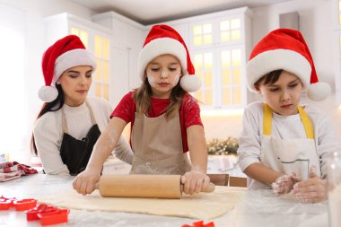 Anne ve küçük tatlı çocukları mutfakta Noel kurabiyesi yapıyorlar.