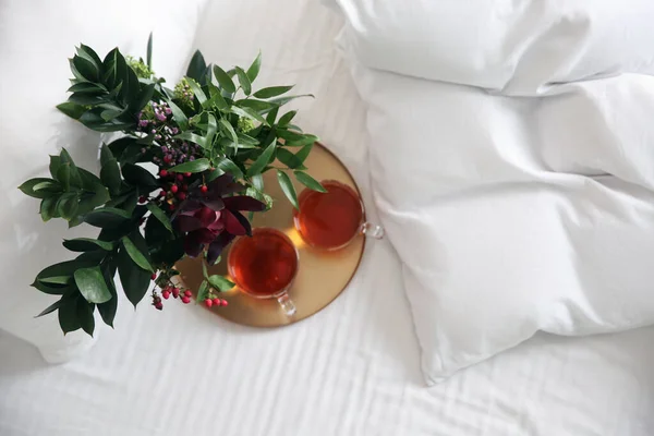 柔らかい毛布の近くの紅茶と花の装飾のカップでベッドでトレイ — ストック写真