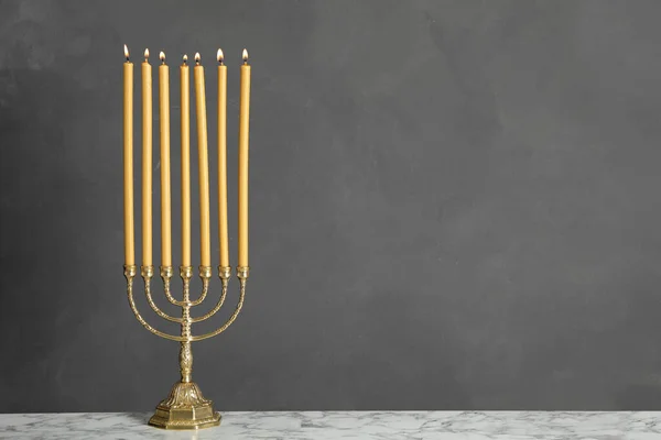 Gyllene Menorah Med Brinnande Ljus Bordet Mot Grå Bakgrund Utrymme — Stockfoto