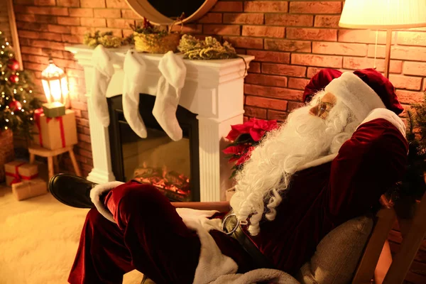 Weihnachtsmann Ruht Neben Dekoriertem Kamin Drinnen — Stockfoto