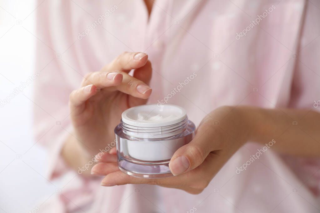Woman with jar of moisturizing cream, closeup