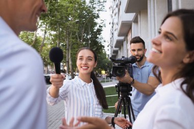 Video kameralı profesyonel gazeteci ve operatör dışarıda röportaj yapıyor.