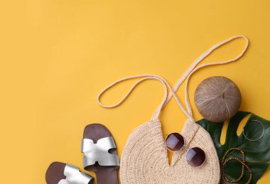 Sarı arka planda saman torbası ve yaz aksesuarları düz.